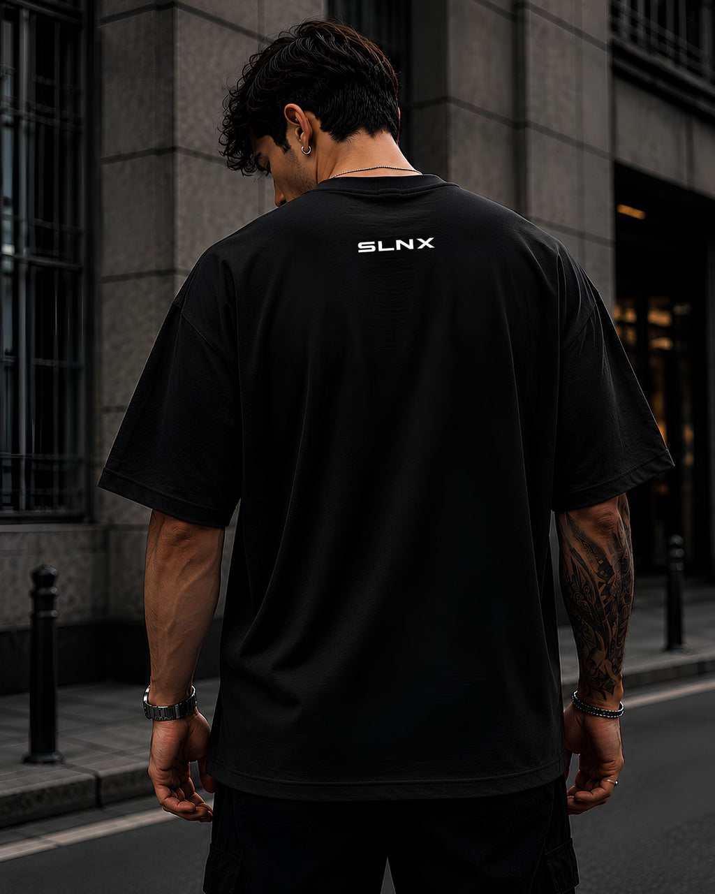 Diseño trasero CONSISTENCY BUILDS CHAMPIONS en polo heavyweight oversized color negro SLNX 