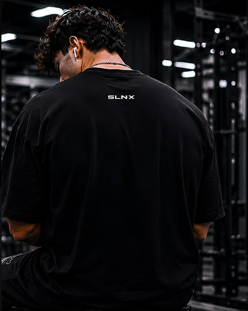 Modelo usando polo oversized NO EXCUSES JUST RESULTS para gym y streetwear COLOR NEGRO